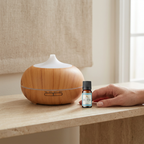Natural pine-finish ultrasonic diffuser beside Devdarshan Stress Relief Aroma Oil, with a hand nearby for scale.